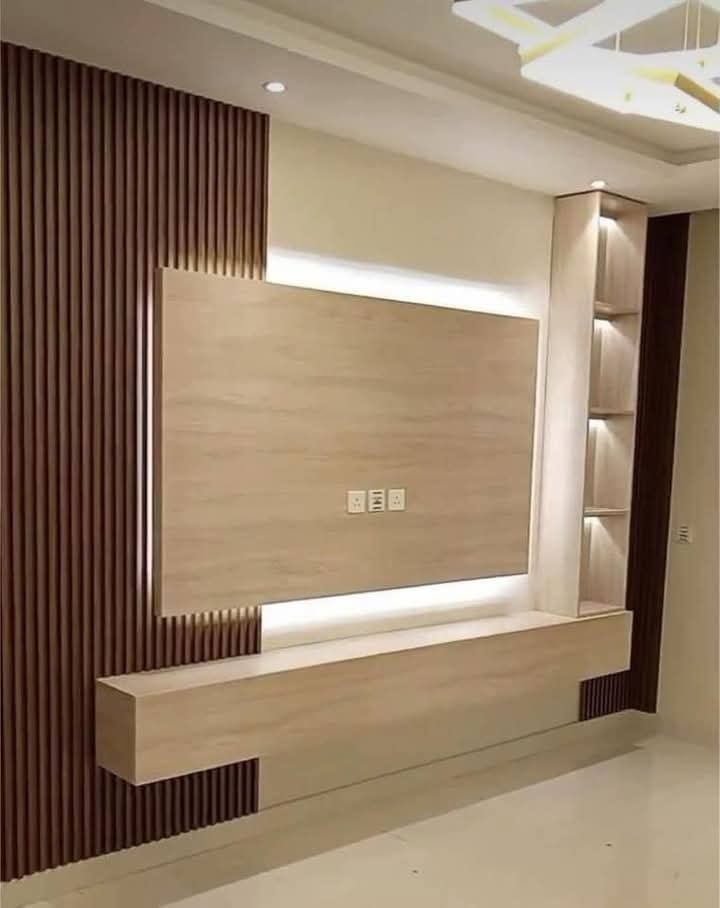 Wooden slat TV panel with warm cove lighting and floating shelves