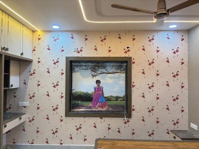 Bedroom feature wall finished in patterned designer wallpaper with framed art